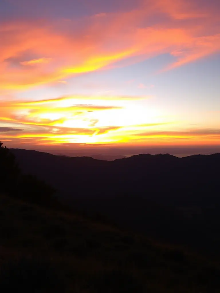 A photograph of a plot in Derekoop Yaşam Vadisi during sunset, emphasizing the scenic views and the peaceful atmosphere. The plot is slightly elevated, offering a panoramic view.